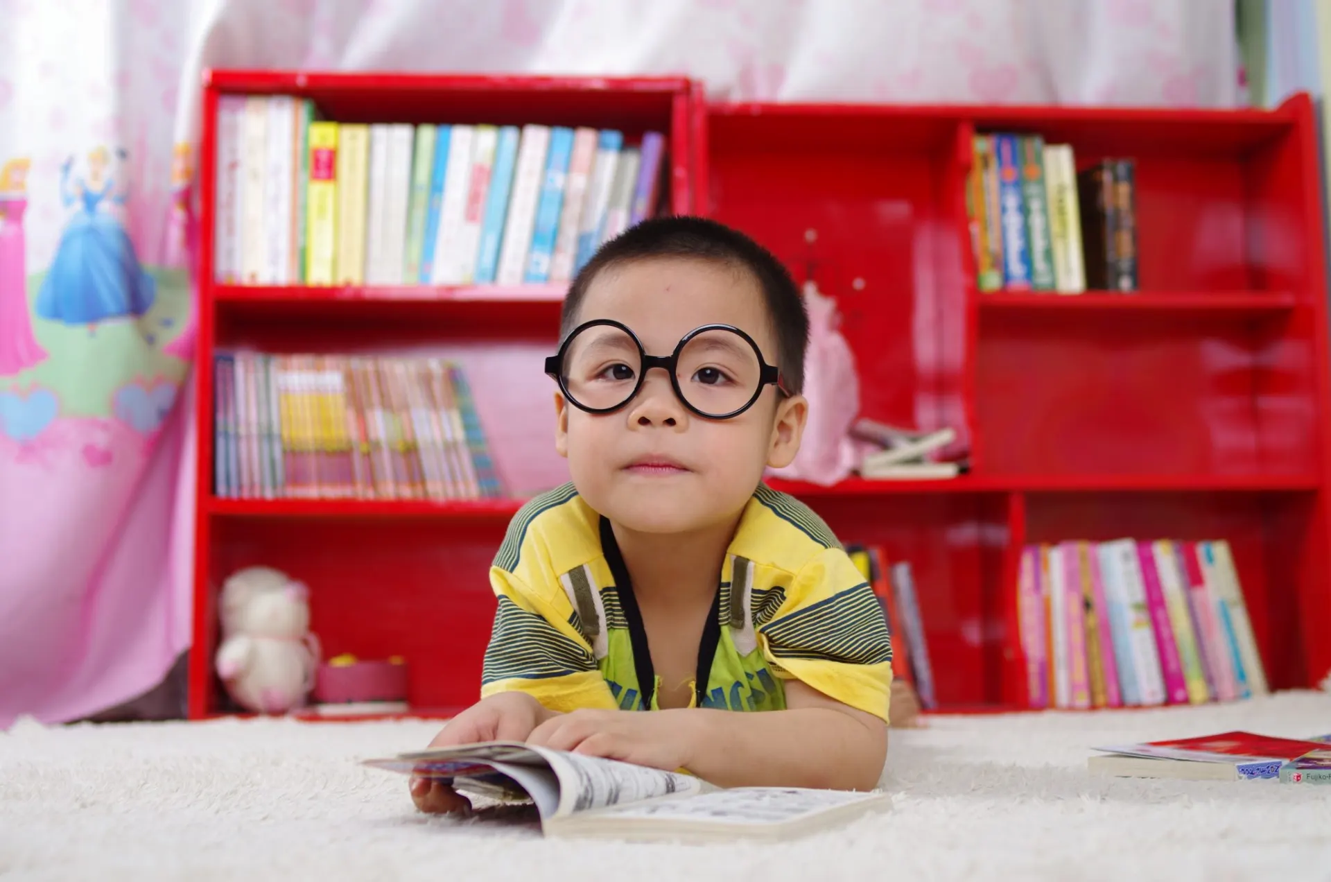 Kid with glasses reading a book