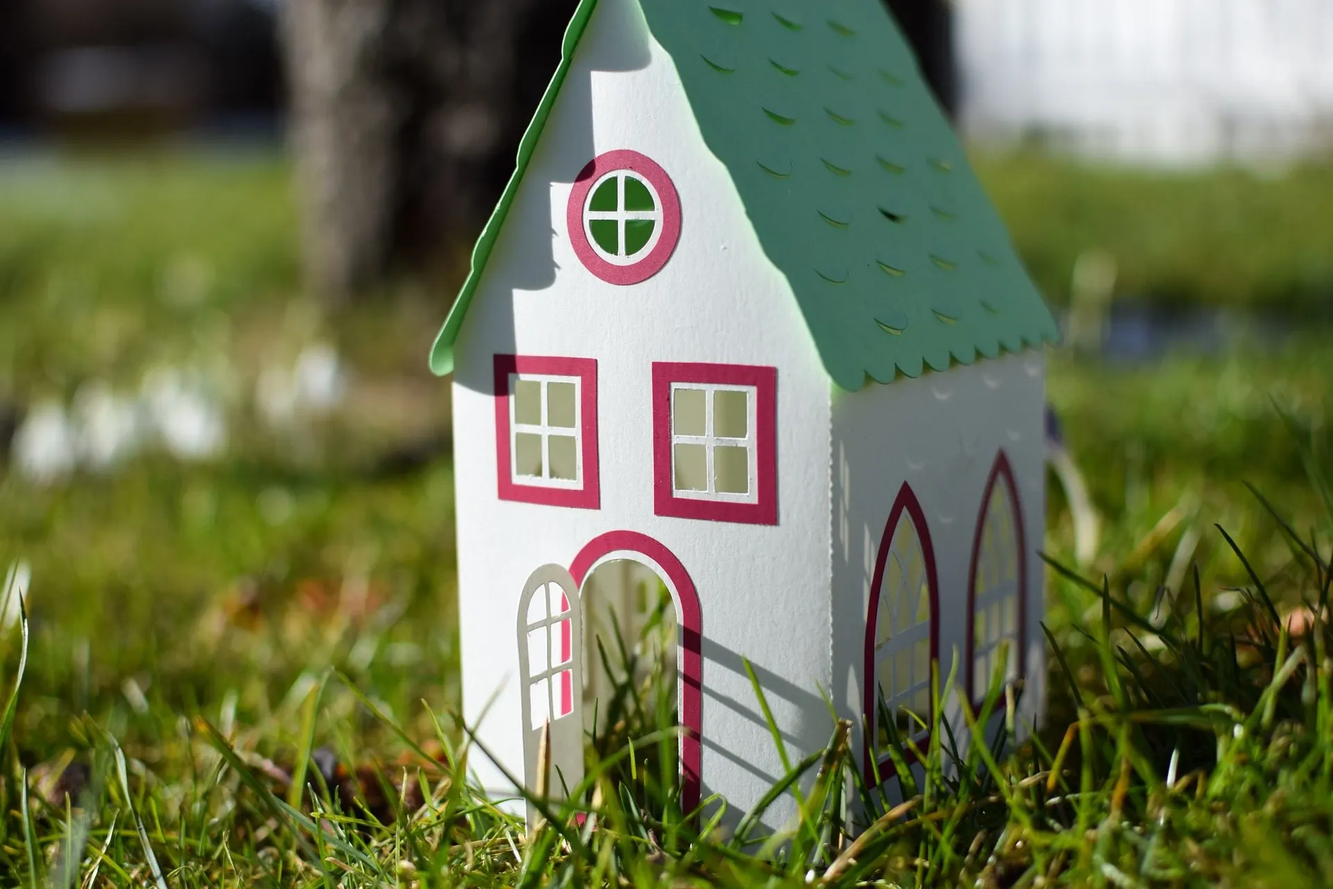 A small toy house sitting in the grass